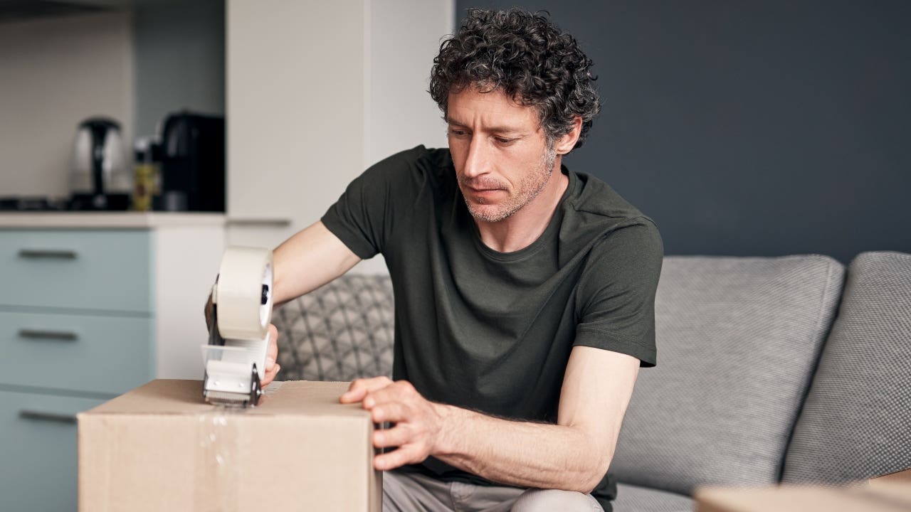 A homeowner boxes up belongings in preparation for a move