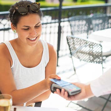 woman making payment at an outdoor restaurant