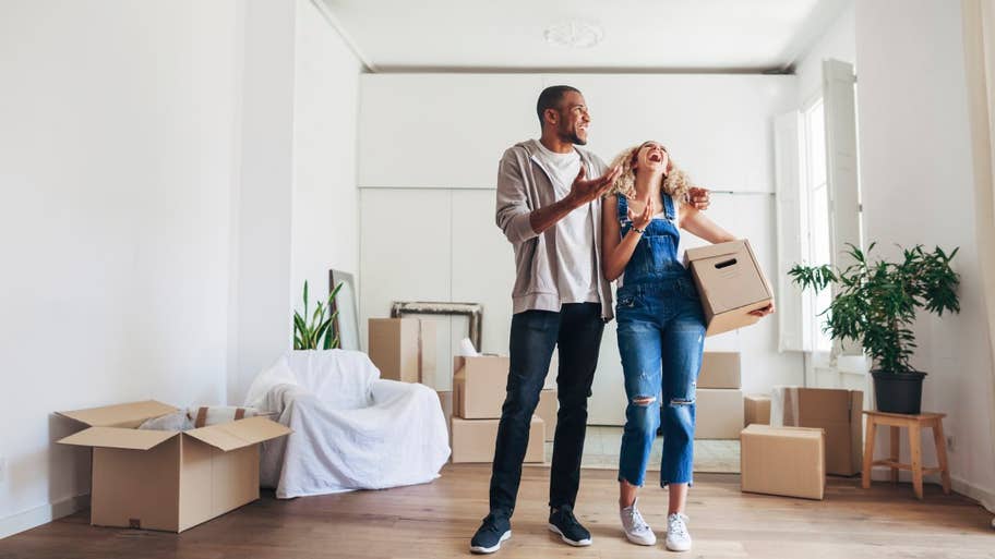 Couple laughing while moving boxes