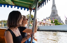 two women riding a boat in bangkok