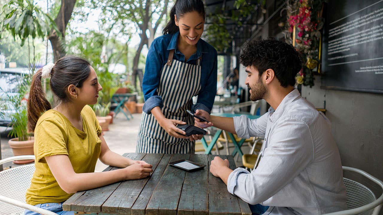 Couple paying at a sidewalk cafe