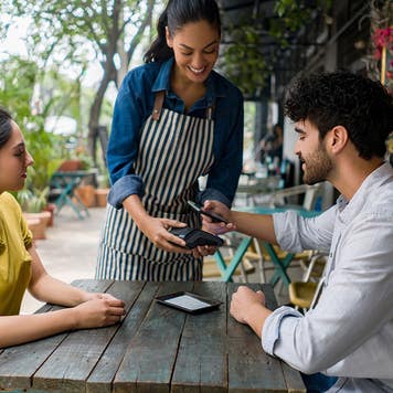 Couple paying at a sidewalk cafe