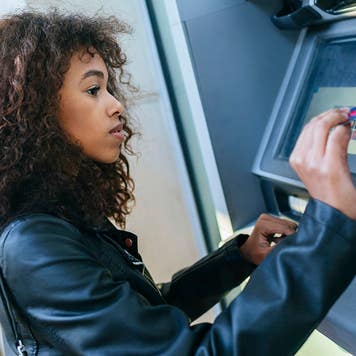 Woman using credit card at ATM
