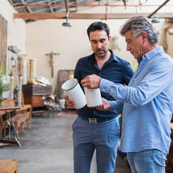 Owner of antique shop talking with customer in his store