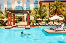 two people swimming and sunbathing at hotel resort pool