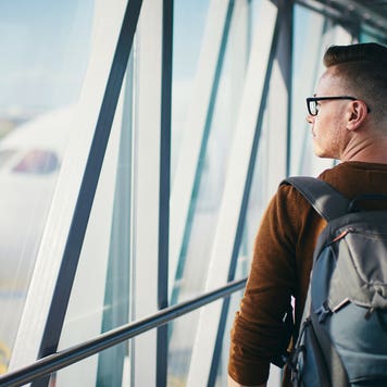 man walking in airport passenger bridge