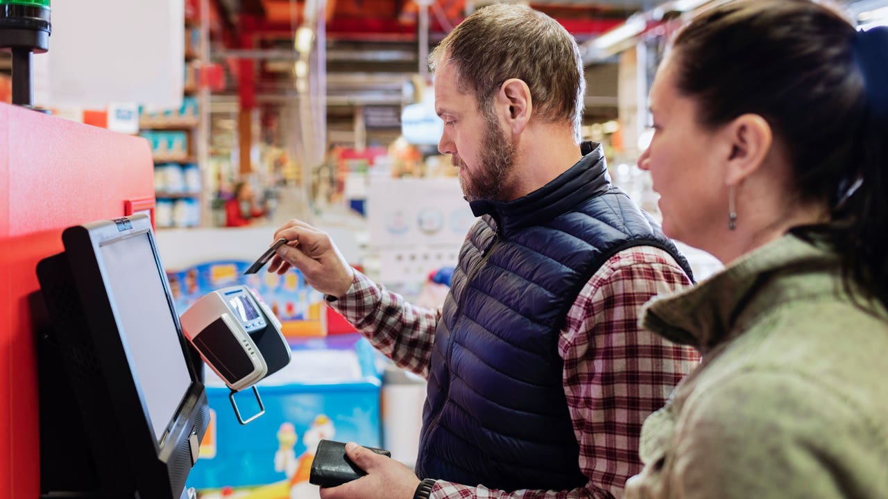 man paying with credit card at the supermarket checkout