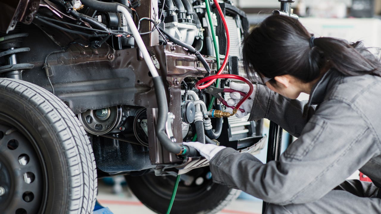 female mechanic working on a car in an auto repair shop