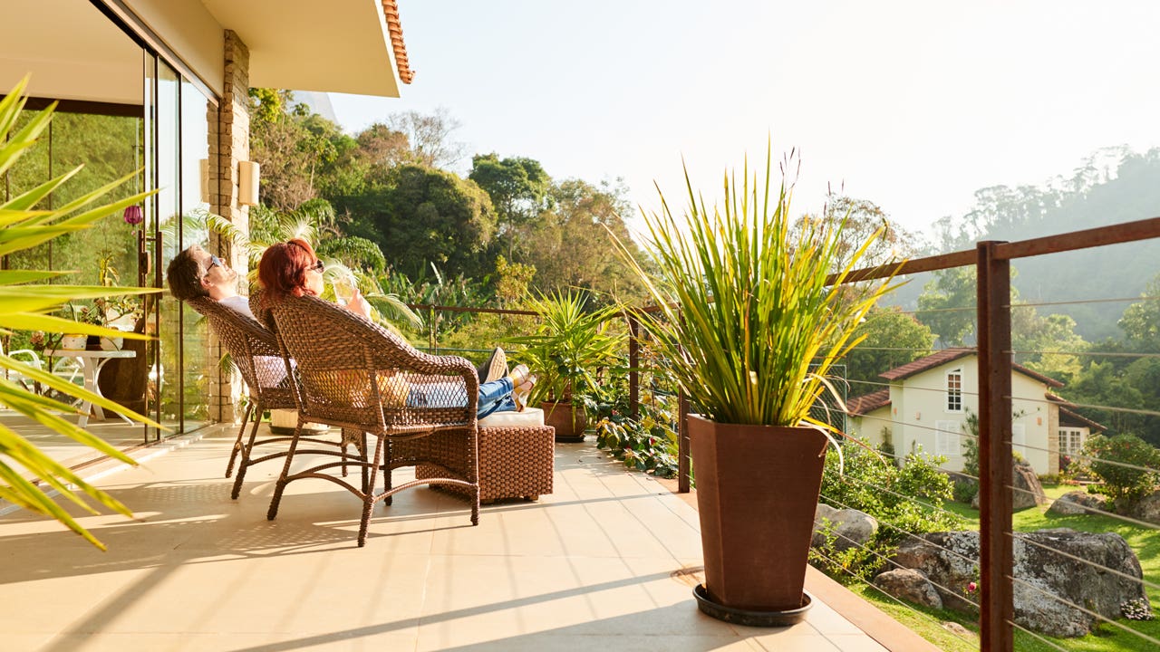 couple relaxing in chairs on hotel balcony