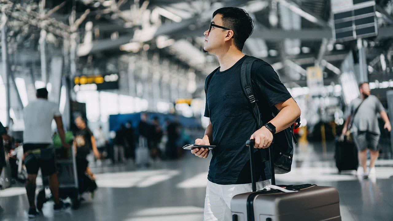 young man at the airport with a suitcase