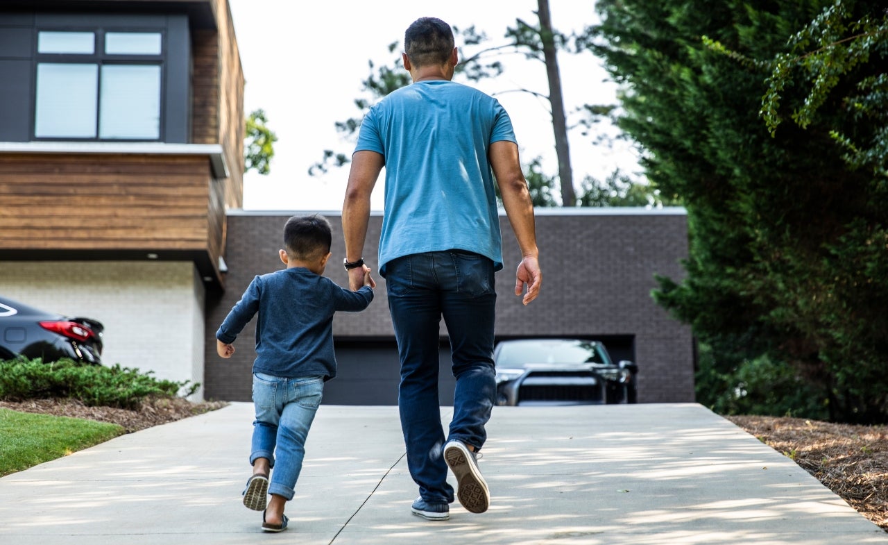 A father and son walk up their driveway