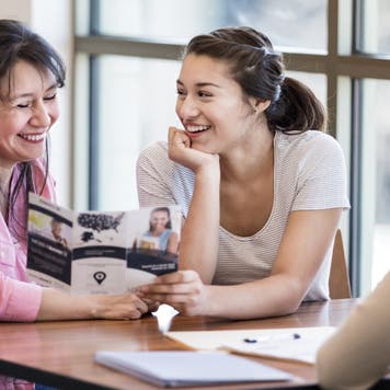 Mother and daughter look at pamphlet for a loan