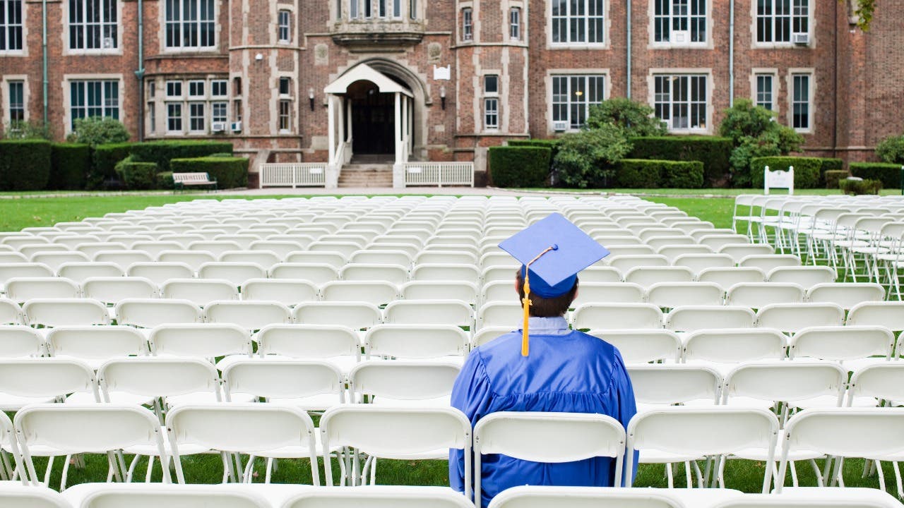 College graduate sits after graduation ceremony