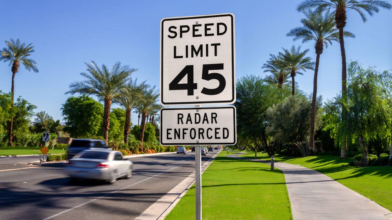 cars passing by a speed limit sign