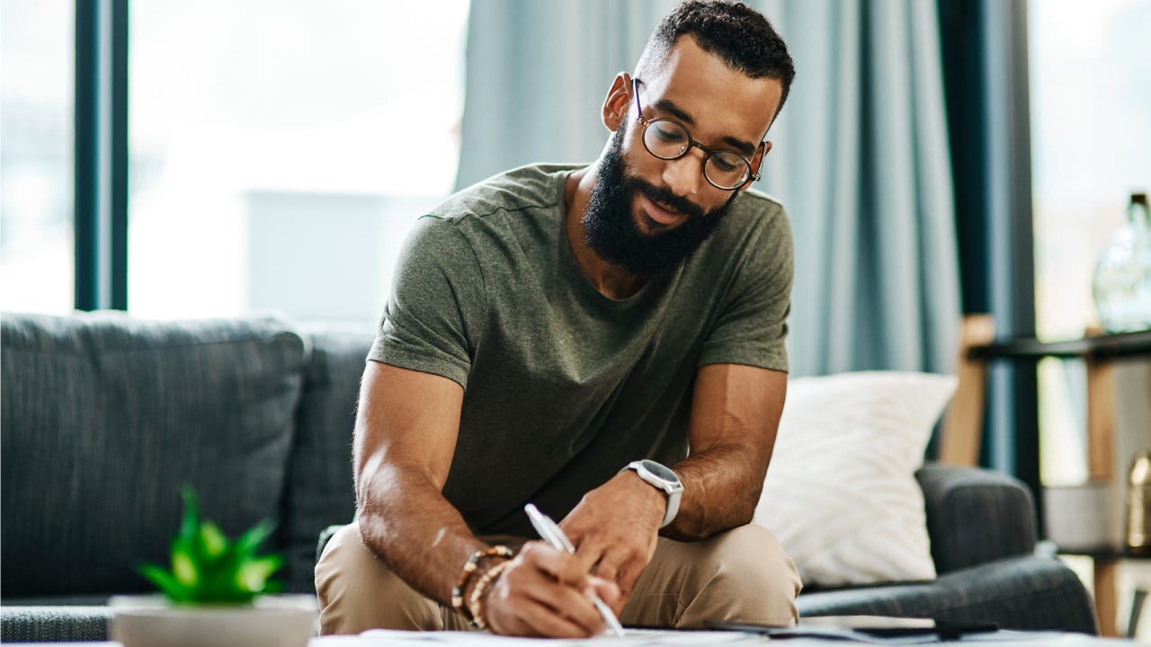 Man balancing finances on paper