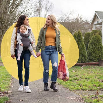 couple walking on a sidewalk with a baby and shopping bags