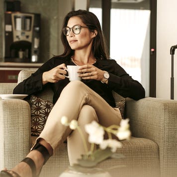 woman holding coffee cup and sitting in airport lounge