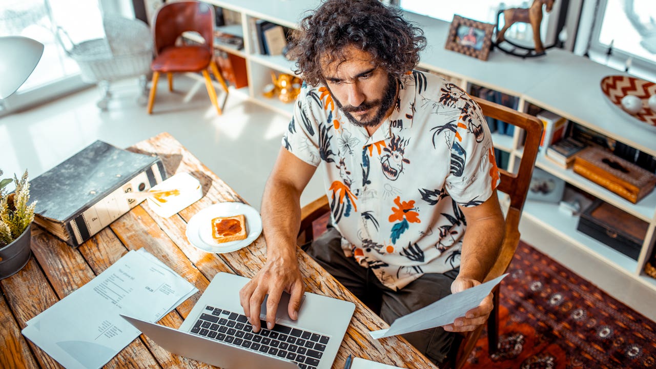 man working on computer in home office