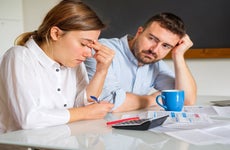 couple looking stressed while analyzing finances
