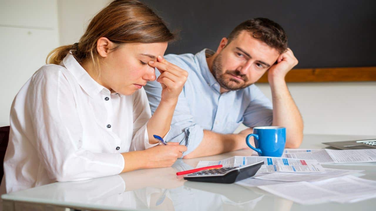 couple looking stressed while analyzing finances