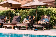 couple relaxing on chairs by a swimming pool