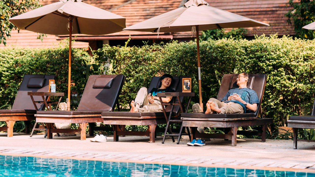 couple relaxing on chairs by a swimming pool