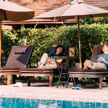 couple relaxing on chairs by a swimming pool