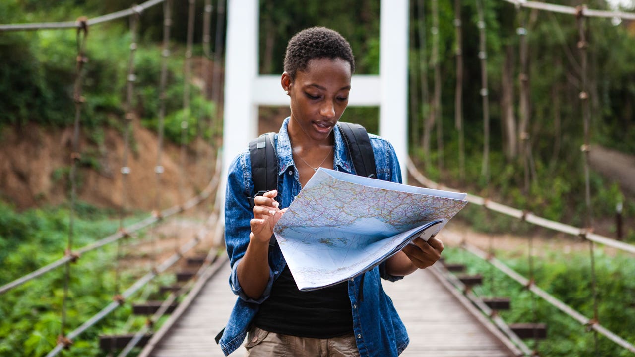 woman looking at a map while traveling