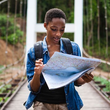 woman looking at a map while traveling