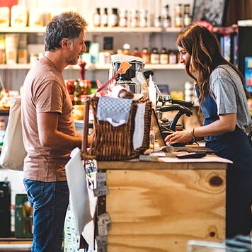 man making purchase at gourmet grocery store