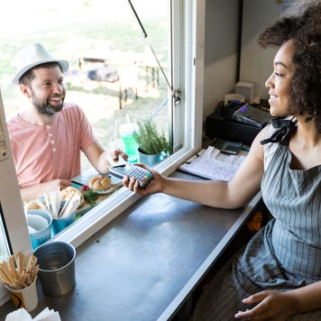 man paying for food with credit card at a food truck
