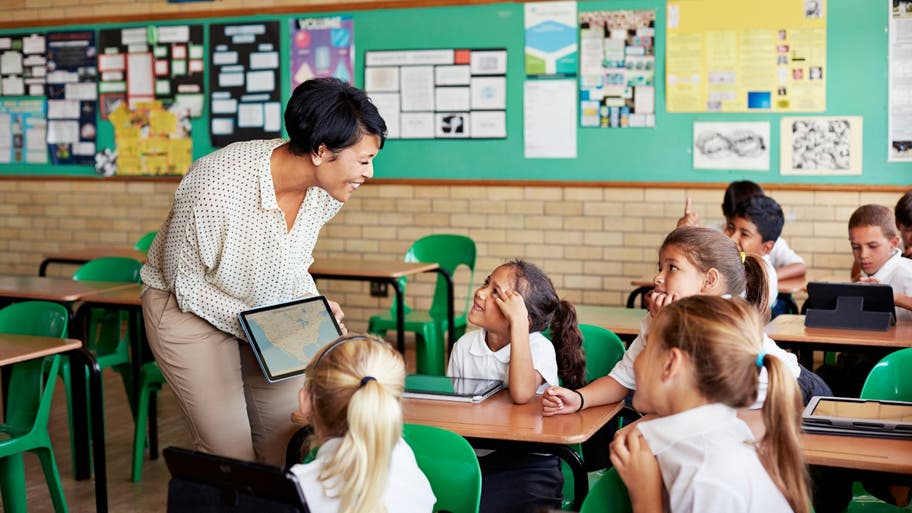 Teacher works with students in a classroom