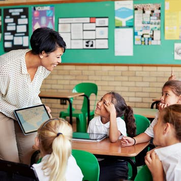 Teacher works with students in a classroom