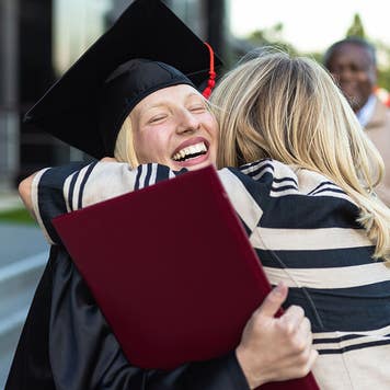 woman hugging her mother at college graduation