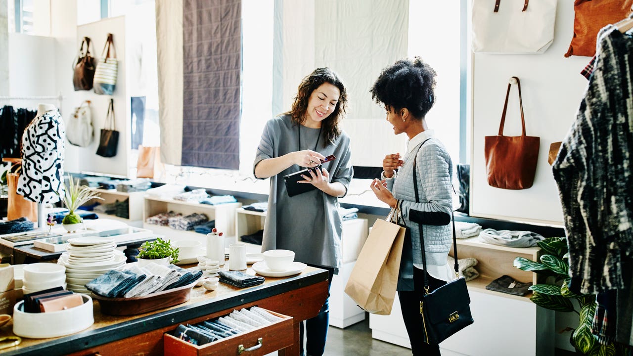 store owner using digital tablet to process credit card transaction with customer