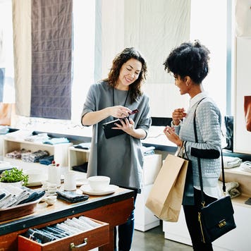 store owner using digital tablet to process credit card transaction with customer