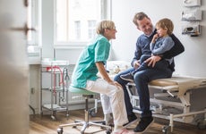 Doctor talks to father and son in clinic