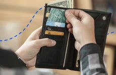 person reaching into a wallet
