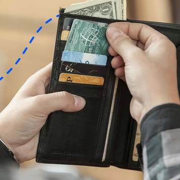person reaching into a wallet