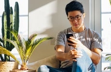 man sitting at home and looking at his phone