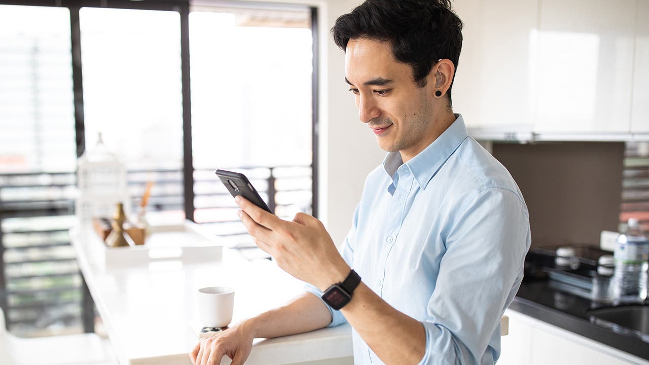 Hearing impaired man using smart phone in the kitchen