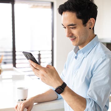 Hearing impaired man using smart phone in the kitchen