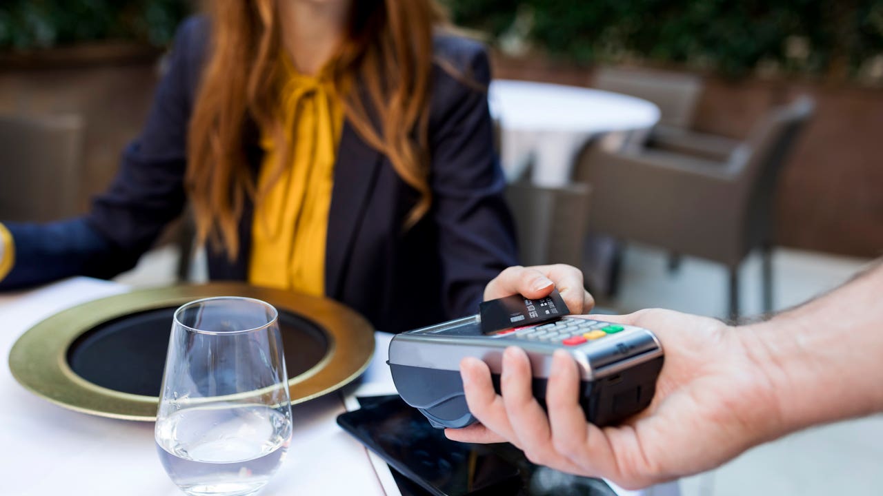 woman at restaurant paying with credit card