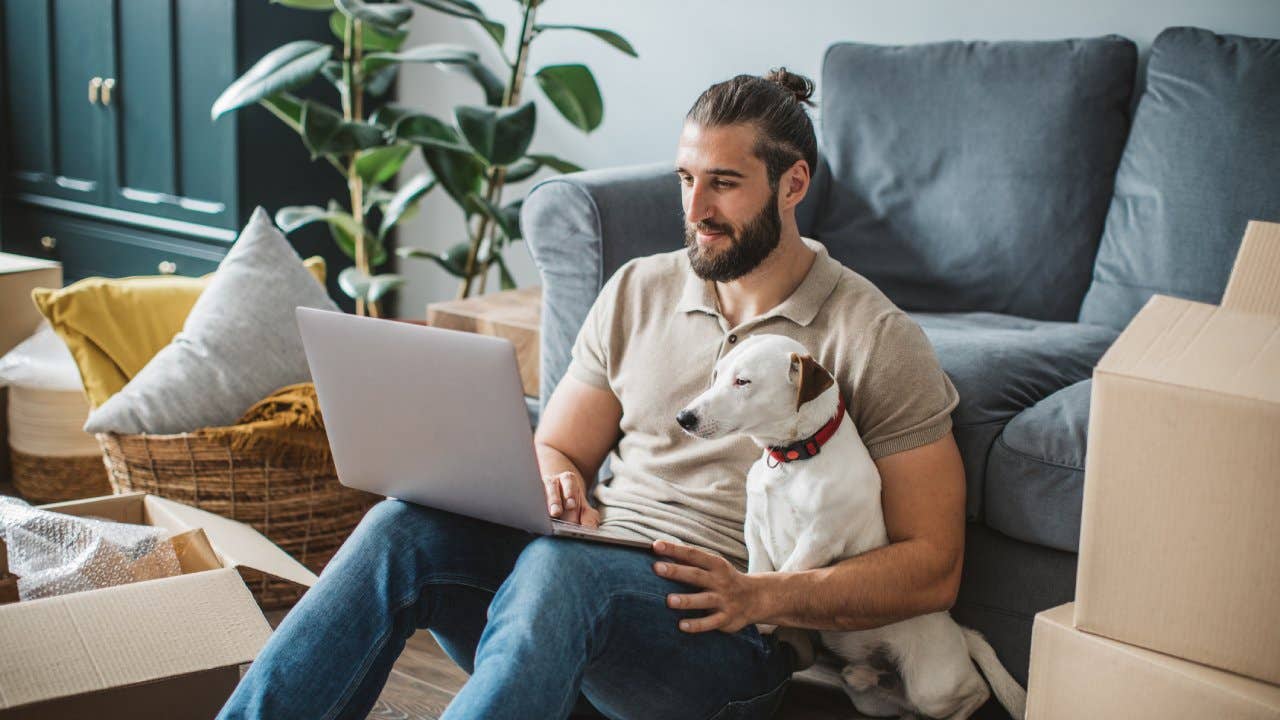 Man sitting with laptop and dog