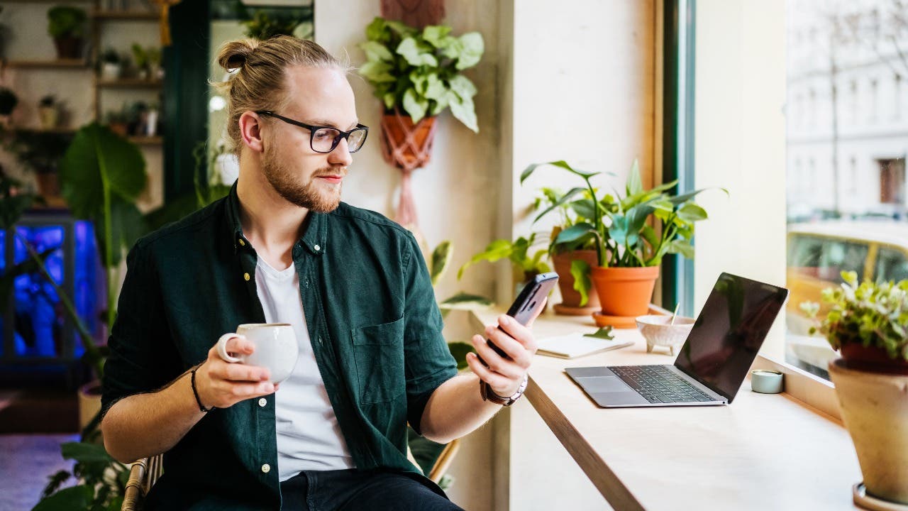 Man checks his phone at a coffee shop