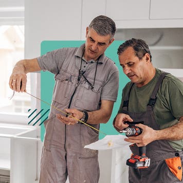 Two contractors making measurements and discussing