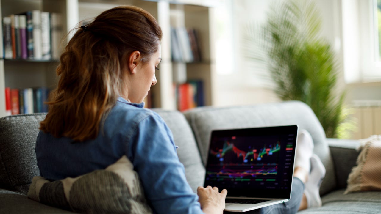 A woman trades stock on her laptop