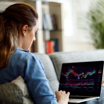 A woman trades stock on her laptop