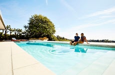 couple sitting by a pool at a vacation rental