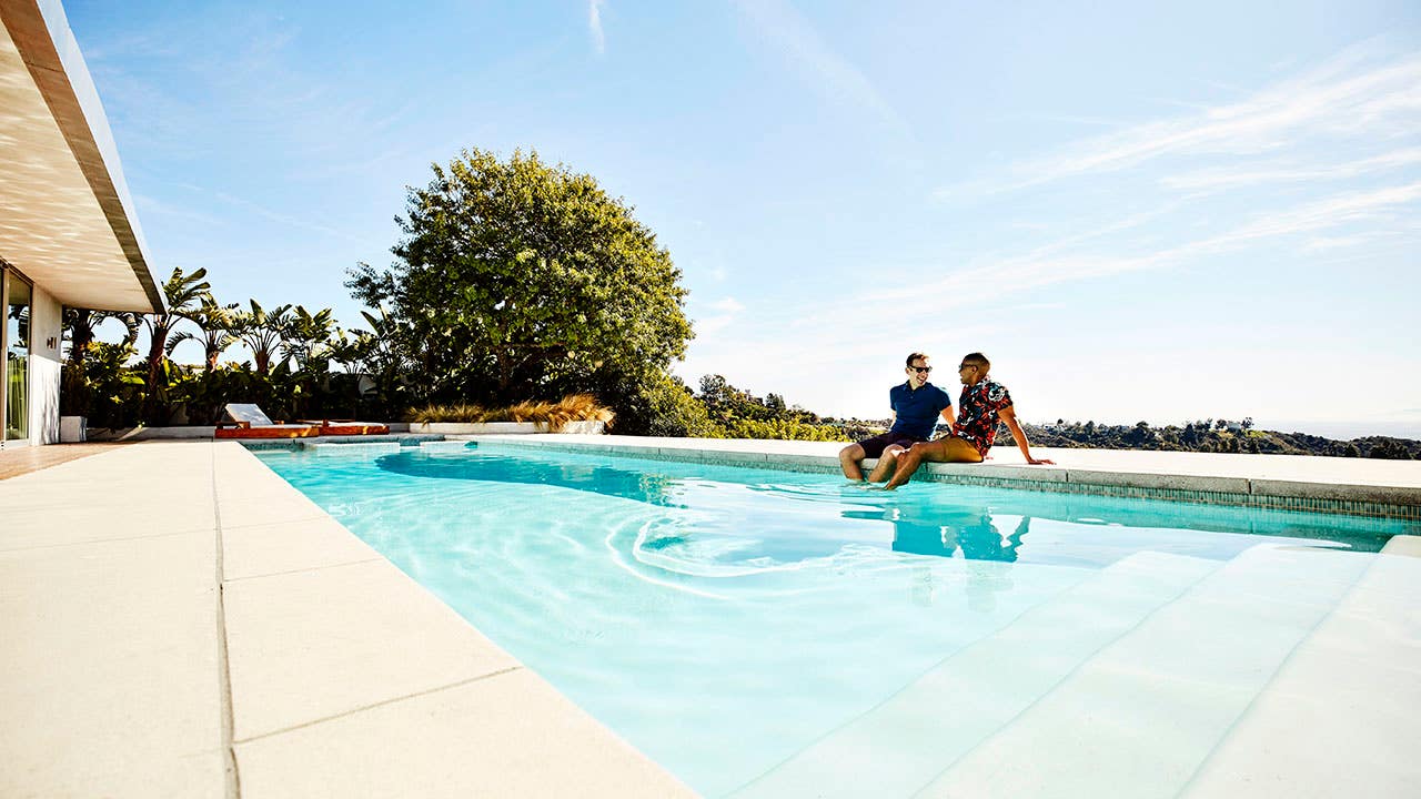 couple sitting by a pool at a vacation rental